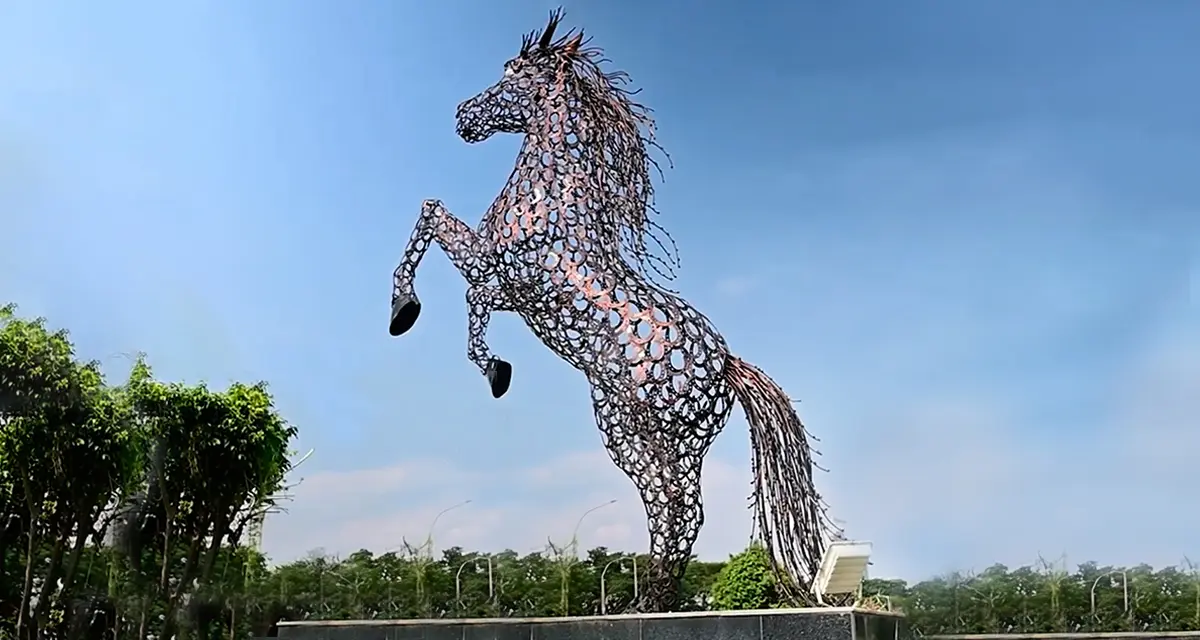 Large, textured metal sculpture of a rearing horse, a dynamic piece of contemporary outdoor art.